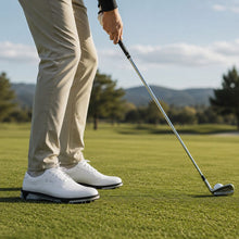 Vita golfskor för herr med spikad sula, sedda vid golfslag