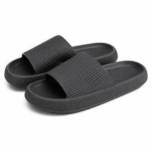 Svarta slip-on-tofflor med mjuk sula och bred rem över tån