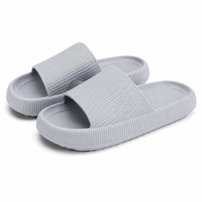 Ljusgrå slip-on-tofflor med mjuk sula och öppen tå