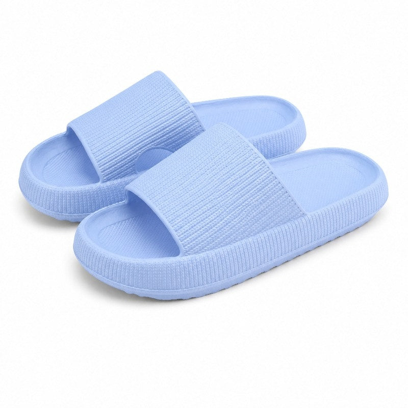 Ljusblå slip-on-tofflor med bred tygrem och mjuk, räfflad sula.