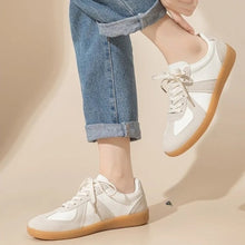 Låga vita sneakers med snörning och guldfärgad sula
