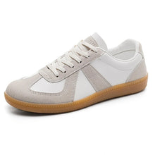 Låga vita sneakers i läderlook med grå paneler och guldfärgad gummisula