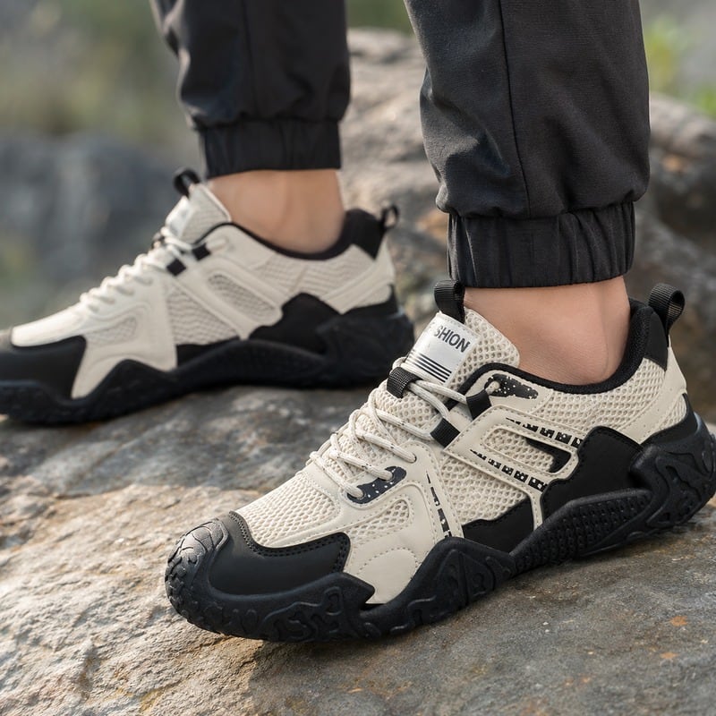 Off-white och svart sneakers med ventilerande mesh, snörning och kraftig slitbana.