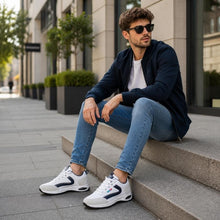 Sneakers i vitt och marinblått med kraftig luftdämpad sula, på fot med jeans