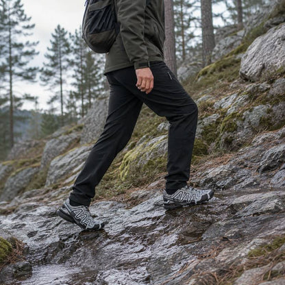 Vandringsskor på klipplig stig, mörka skor med mönstrad gummisula