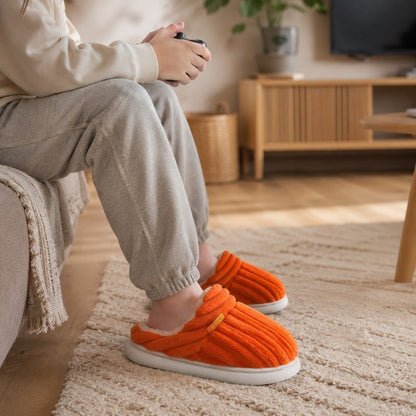 Barnofflor med mjukt fleecefoder i orange, randig ovandel och vit sula.